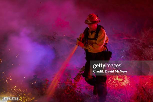 Firefighters control a backfire they set at the Maria Fire, which exploded to 8,000 acres on its first night, on November 1, 2019 near Somis,...