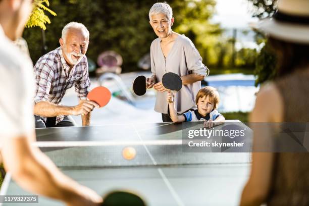 happy extended family having fun while playing table tennis in the backyard. - friends table tennis stock pictures, royalty-free photos & images