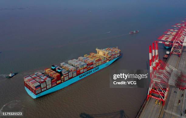 Tugboats guide a container ship of Maersk Line at the Yangshan Deepwater Port, operated by Shanghai International Port Co., Ltd. , on October 4, 2019...