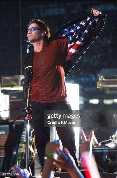 Bono, lead singer of U2, displays American flag lining in his jacket after singing "Where The Streets Have No Name", during the halftime show of...