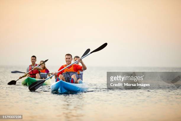 couples kayaking on river during summer sunset - kayaking stock pictures, royalty-free photos & images