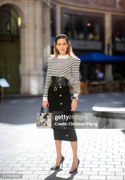 Alexandra Lapp is seen wearing a black and white striped pullover with shoulder pads from saint Laurent, black pencil skirt with golden buttons from...