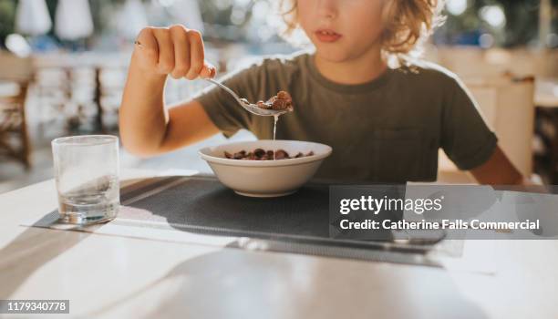 eating cereal - children eating breakfast stockfoto's en -beelden