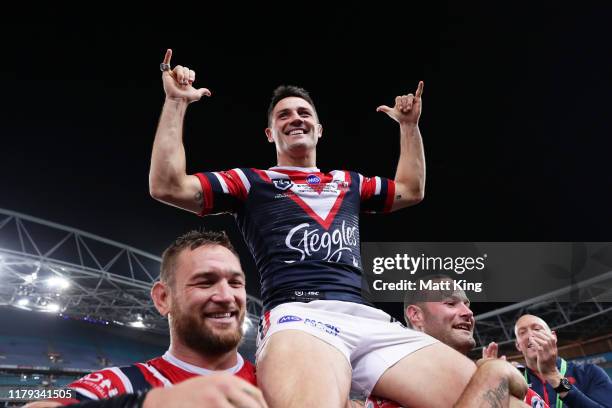 Cooper Cronk of the Roosters is chaired off the field by Jared Waerea-Hargreaves and Boyd Cordner during the 2019 NRL Grand Final match between the...