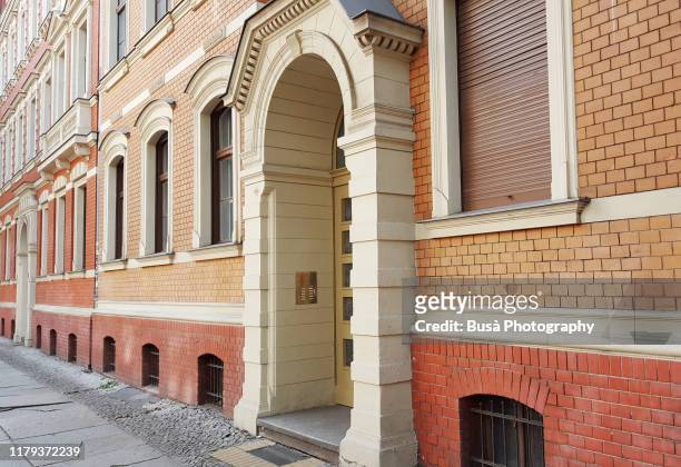 entrance of red brick residential building in the pappelallee / buchholzer strasse street, in the district of prenzlauer berg in the east side of berlin, germany - berlin prenzlauer berg stock-fotos und bilder