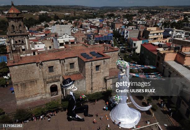 Aerial view of a 20-meter-high "Catrina" figure -the biggest in the world-, dressed up as a bride, and the "Catrin", her groom, in the main square of...