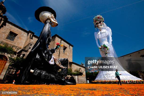 View of a 20-meter-high "Catrina" figure -the biggest in the world-, dressed up as a bride, and the "Catrin", her groom, in the main square of...