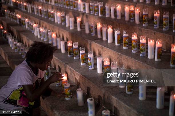 Youngster lights a candle during a protest to mark the 600 days of Brazilian murdered councilwoman Marielle Franco's murder in Rio de Janeiro,...