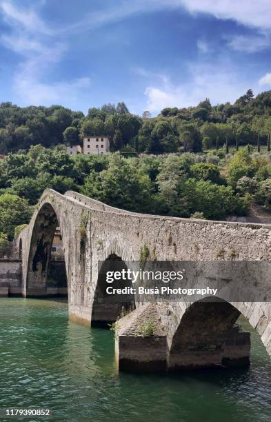 the medieval ponte della maddalena or devil's bridge (italian: ponte del diavolo) in borgo a mozzano, near lucca, tuscany, italy - ponte del diavolo - fotografias e filmes do acervo