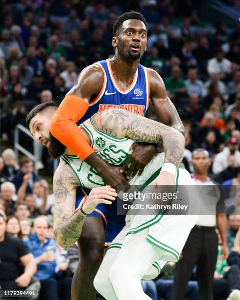 Bobby Portis of the New York Knicks holds onto Vincent Poirier of the Boston Celtics in the second half at TD Garden on November 1, 2019 in Boston,...