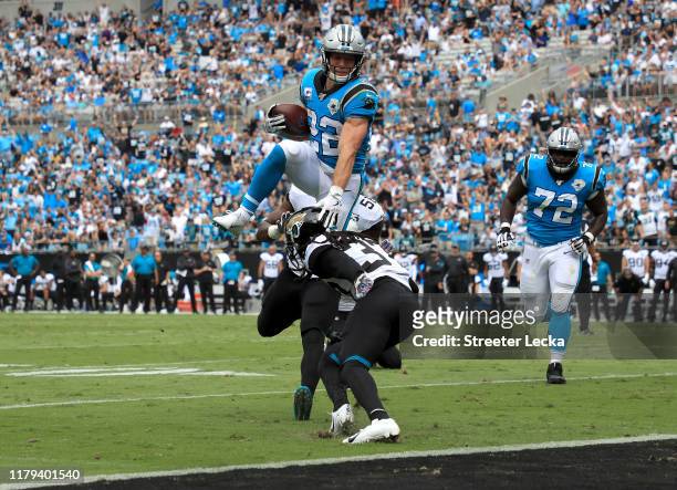 Christian McCaffrey of the Carolina Panthers jumps over Tre Herndon of the Jacksonville Jaguars for a touchdown during their game at Bank of America...