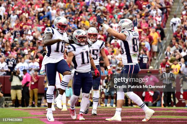 Julian Edelman of the New England Patriots is congratulated by his teammates Josh Gordon, Ryan Izzo and Matt LaCosse after scoring a first quarter...