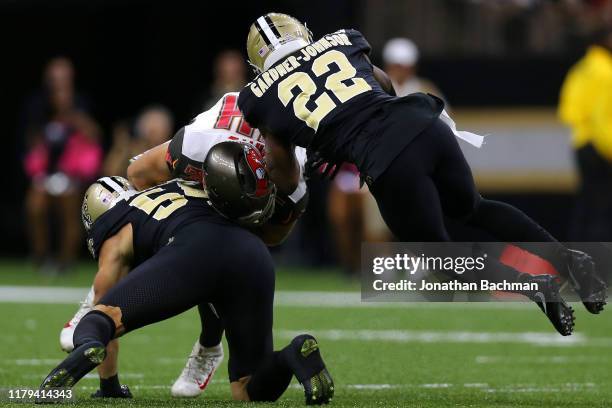 Cameron Brate of the Tampa Bay Buccaneers is tackled by Chauncey Gardner-Johnson of the New Orleans Saints and Kiko Alonso during the first half of a...