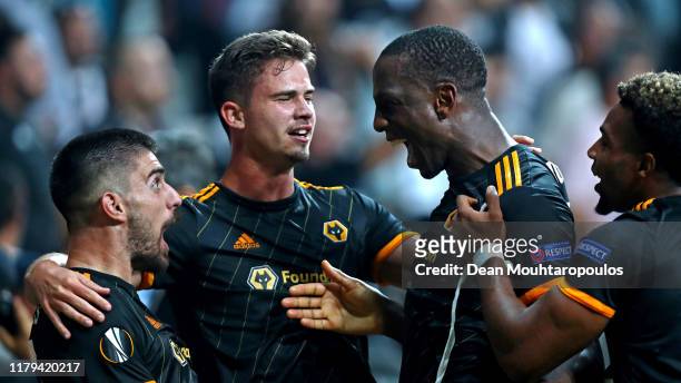 Willy Boly of Wolverhampton Wanderers celebrates with teammates Ruben Neves and Leander Dendoncker after scoring his team's first goal during the...