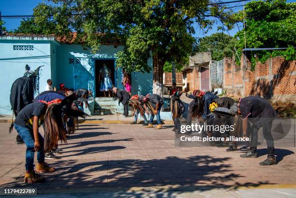 November 2019, Mexico, Cuajinicuilapa: Young people dance with costumes of the devil in front of a house during the traditional "Dance of the Devils"...