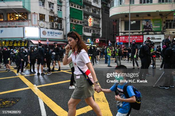 Pedestrians walk pass protestors during a rally in Causeway bay on November 2, 2019 in Hong Kong, China. Hong Kong slipped into a technical recession...