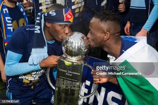Edward Chilufya and Buya Turay of Djurgardens IF kiss the Lennart Johansson trophy after Djurgardens IF wins the 2019 Allsvenskan season during an...
