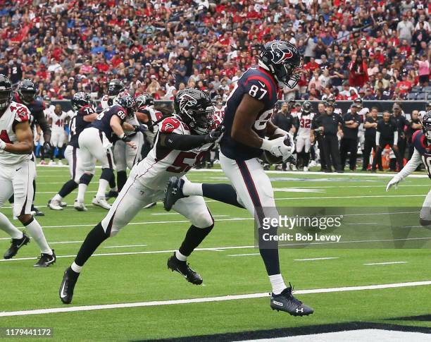 Darren Fells of the Houston Texans scores on a eight yard pass from Deshaun Watson as De'Vondre Campbell of the Atlanta Falcons is unable to make a...