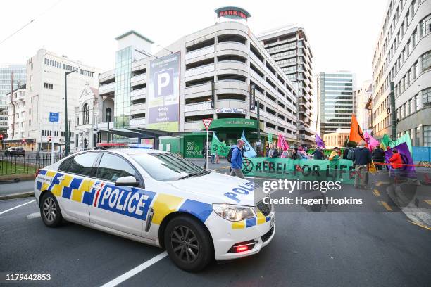 Police car parked in front of protesters during an Extinction Rebellion protest on October 07, 2019 in Wellington, New Zealand. The event was...