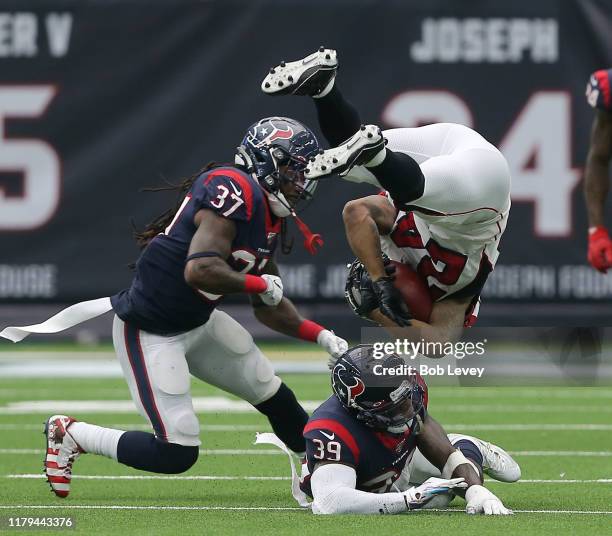 Devonta Freeman of the Atlanta Falcons is upended by Tashaun Gipson of the Houston Texans and Jahleel Addae during the second half at NRG Stadium on...