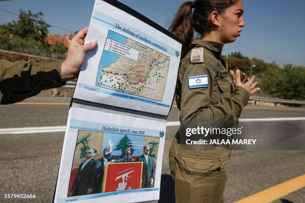 Picture taken on October 30, 2019 from a location near the northern Israeli town of Avivim shows an Israeli Army soldier with a map and a picture of...