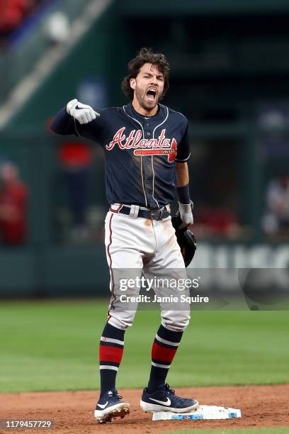 Dansby Swanson of the Atlanta Braves celebrates after hitting an RBI double to tie the game against the St. Louis Cardinals during the ninth inning...