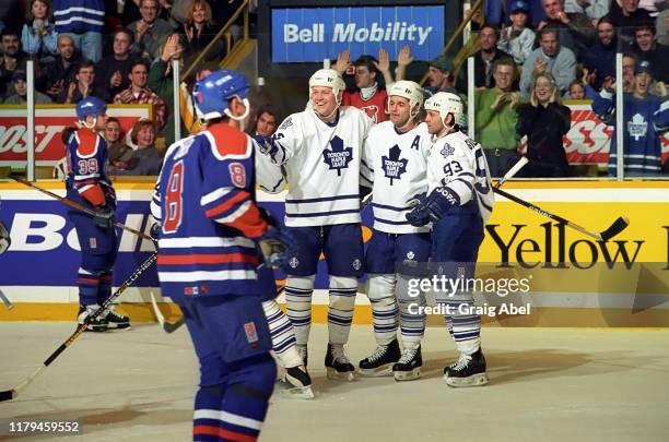 Mats Sundin, Dave Ellett and Doug Gilmour of the Toronto Maple Leafs skate against Zdeno Ciger and the Edmonton Oilers during NHL game action on...