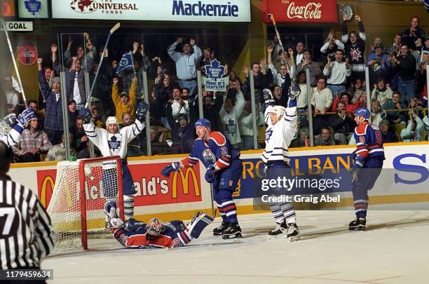 Doug Gilmour and teammates of the Toronto Maple Leafs celebrate against Bill Ranford, Boris Mironov, and Zeno Ciger of the Edmonton Oilers during NHL...