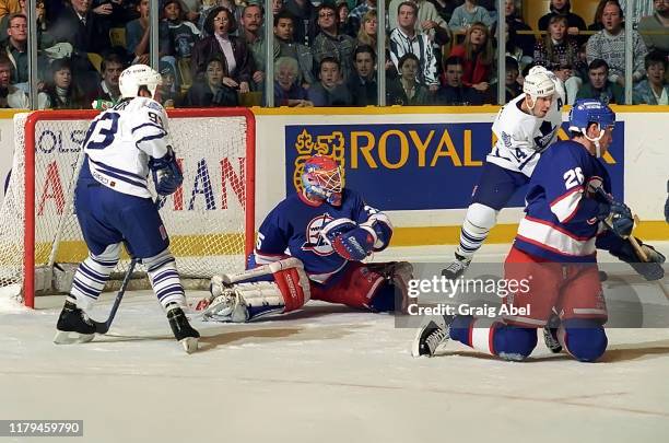 Nikolai Khabibulin and Jeff Finley of the Winnipeg Jets skate against Doug Gilmour and Dave Andreychuk of the Toronto Maple Leafs during NHL game...
