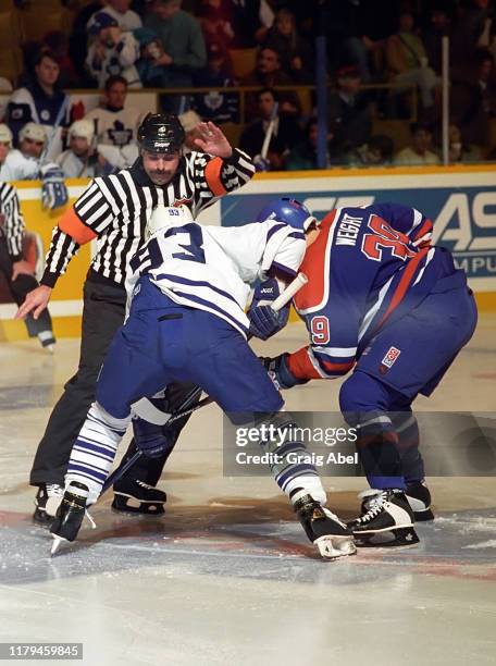 Referee Bill McCreary drops the puck between Doug Wight of the Edmonton Oilers and Doug Gilmour of the Toronto Maple Leafs during NHL game action on...