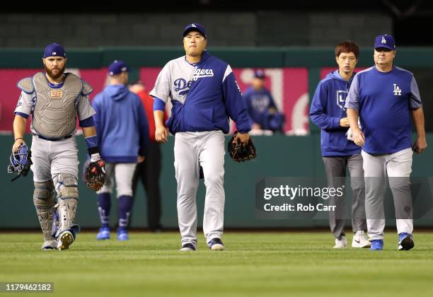 Catcher Russell Martin, pitcher Hyun-Jin Ryu and pitching coach Rick Honeycutt of the Los Angeles Dodgers walk on the field before Game 3 of the NLDS...