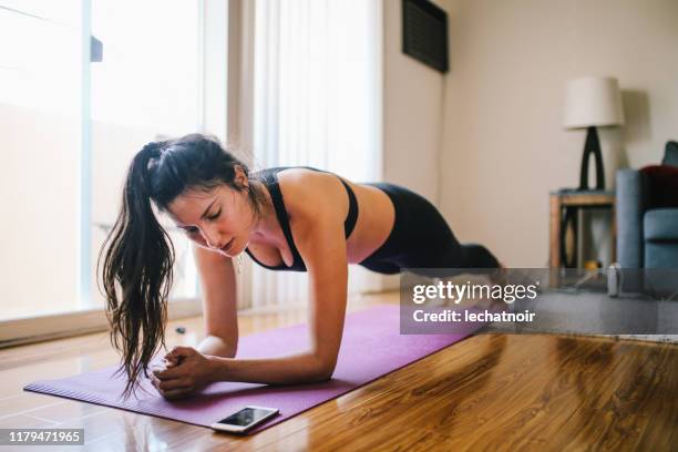 donna che esercita tavole a casa a los angeles - plank exercise foto e immagini stock