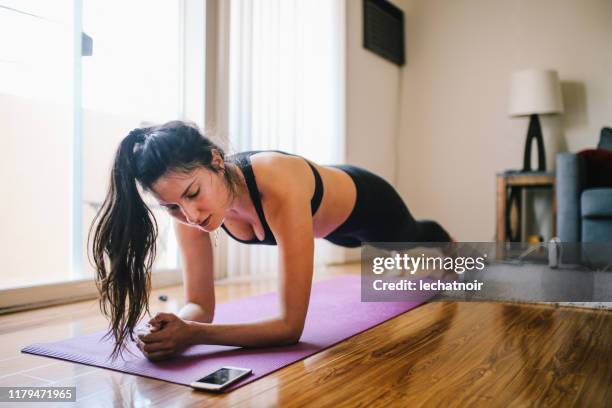 在洛杉磯的家中鍛煉木板的婦女 - plank exercise 個照片及圖片檔