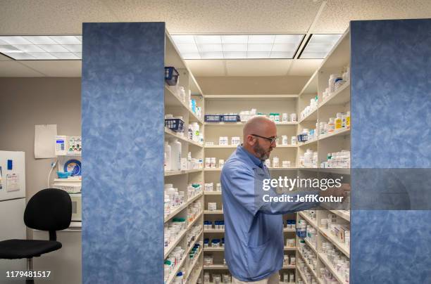 pharmacist picking medicines off a shelf - kontur stock pictures, royalty-free photos & images