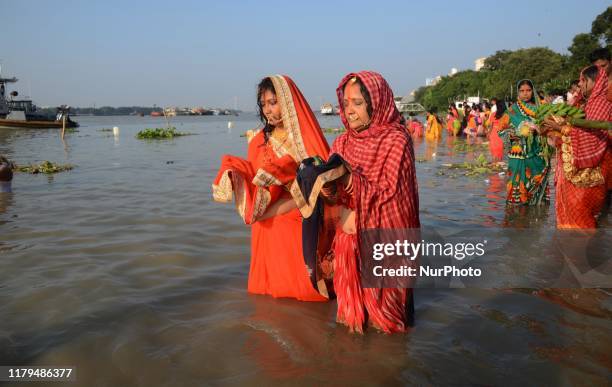 Indian Hindu women devotees offering prayers to the Sun God on the banks of river Ganges in Kolkata , India on Saturday, 2nd November 2019. The...