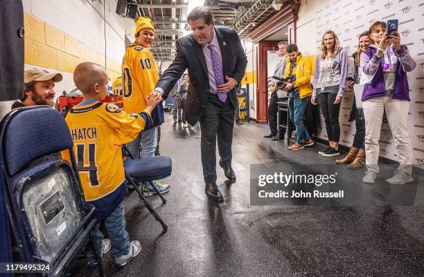 Nashville Predators head coach Peter Laviolette greets cancer patient Sam Hatch during the Hockey Fights Cancer game against the New York Rangers at...