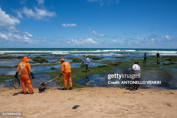 Municipality workers and volunteers clean oil at a beach in Lauro de Freitas, Bahia state, Brazil, on November 2, 2019. - The beaches of Buraco da...