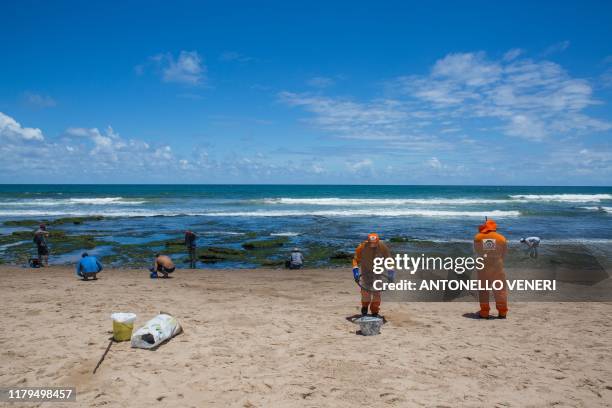 Municipality workers and volunteers clean oil at a beach in Lauro de Freitas, Bahia state, Brazil, on November 2, 2019. - The beaches of Buraco da...