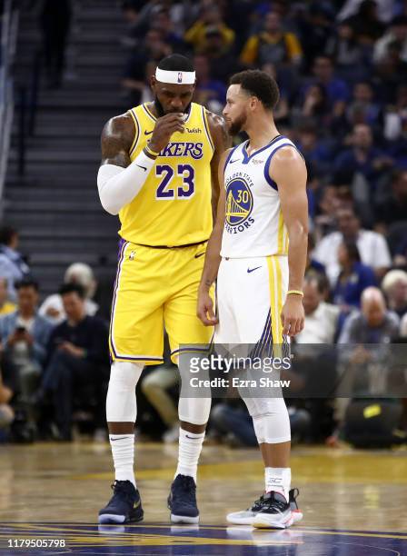 LeBron James of the Los Angeles Lakers talks to Stephen Curry of the Golden State Warriors during their game at Chase Center on October 05, 2019 in...