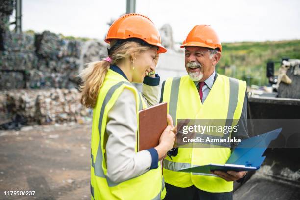 relaxed waste management experts sharing findings onsite - waste management stock pictures, royalty-free photos & images