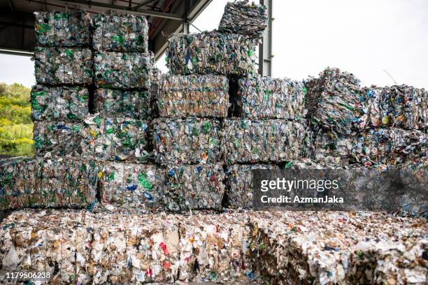 ballen aus komprimierten recycelbaren materialien im freien gestapelt - recyclingmaterial stock-fotos und bilder