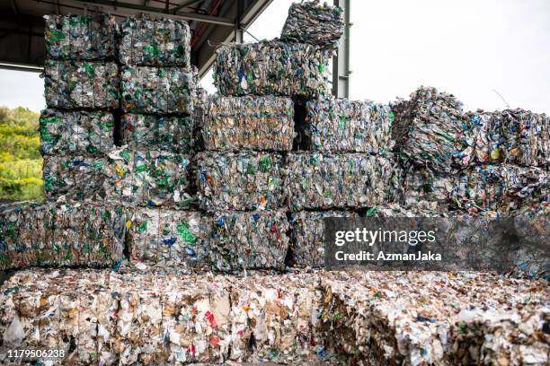 bales of compressed recyclable materials stacked outdoors - material reciclado imagens e fotografias de stock