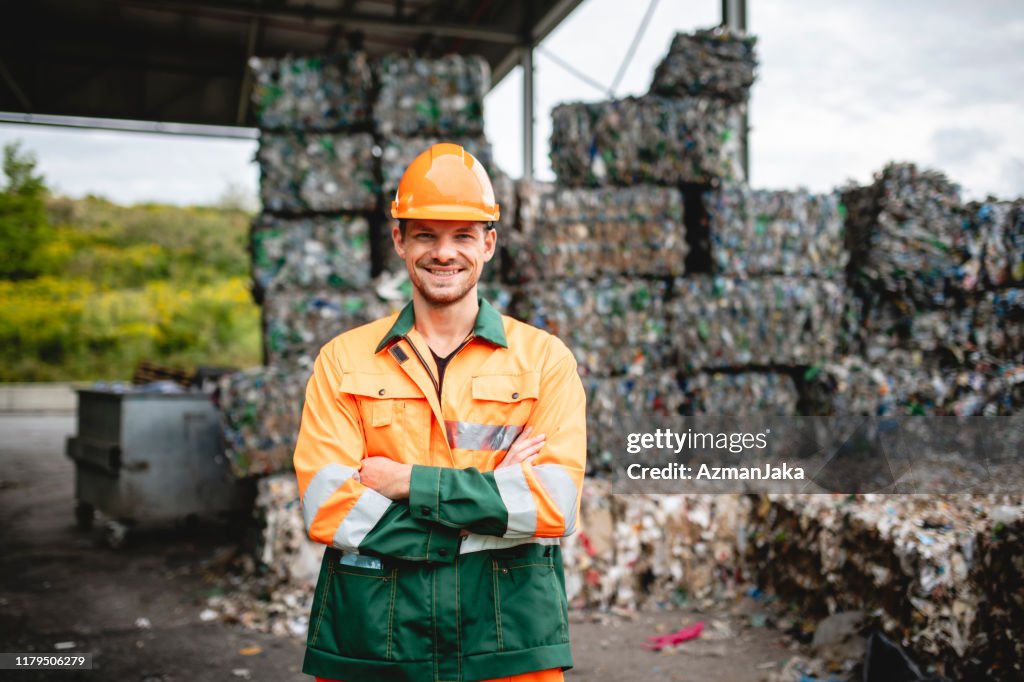 Workman de sorriso ao ar livre na facilidade da gerência waste