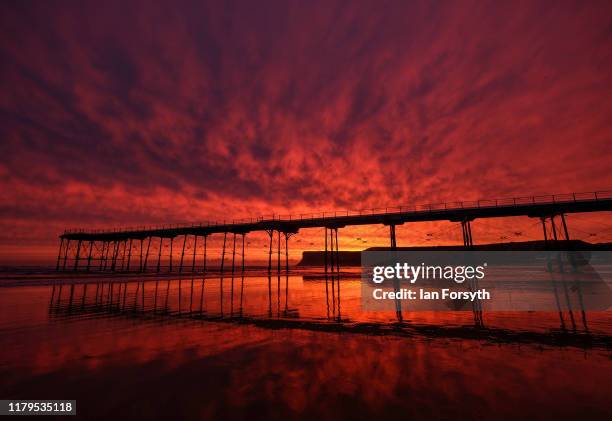 Brief but fiery sunrise rises behind Saltburn pier and cliffs on October 07, 2019 in Saltburn By The Sea, England. Heavy rain in the west will...