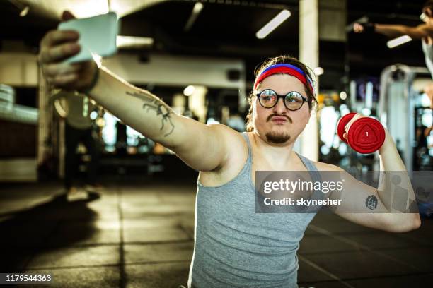 funny nerdy athlete showing off while taking a selfie in a gym. - nerd fun stock pictures, royalty-free photos & images