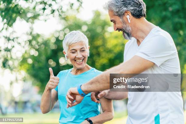 senior couple using sports technologies - pedometer stock pictures, royalty-free photos & images