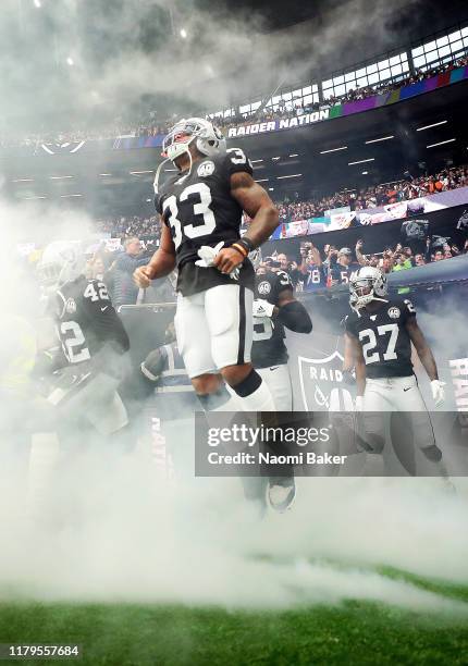 DeAndre Washington of Oakland Raiders jumps in the air as he enters the field ahead of the game between Chicago Bears and Oakland Raiders at...