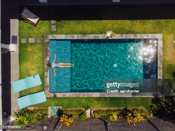 woman floating on pool at bali - swimming pool imagens e fotografias de stock