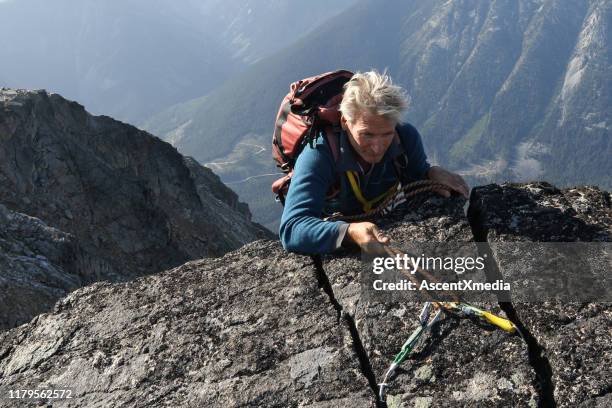 mountaineer rappels himself off cliff - climbing a mountain stock pictures, royalty-free photos & images