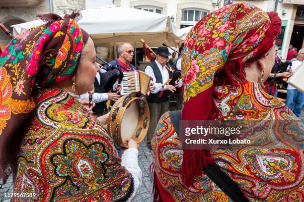 People in traditional costumes dance and play Galician music with bagpipes, tambourines and accordion in the Plaza del Campo the historic center...